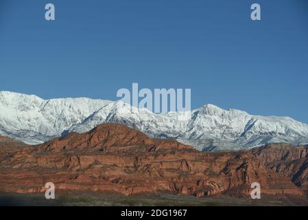 Ein Panorama von wunderschön kontrastierenden Farben in dieser hohen Wüstenlandschaft mit schneebedeckten Bergen mit rauen roten Klippen in Süd-Utah, U geschichtet Stockfoto