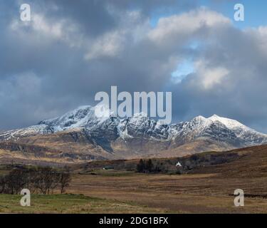 Am frühen Morgen bricht die Sonne auf einen schneebedeckten Blabheinn in der Nähe von Torrin, Isle of Skye, Schottland Stockfoto