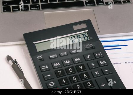 Taschenrechner, Stift und Notebook aus nächster Nähe. Jahresabschlüsse. Dokumente auf dem Desktop im Büro. Unternehmensberichte. Geschäftskonzept. Stockfoto
