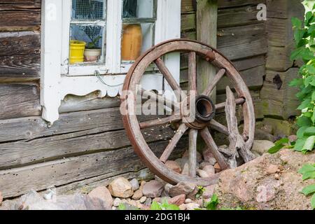 Altes Holzrad in Weide in der Nähe von alten Woddenhaus in Litauen Stockfoto