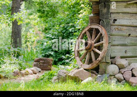 Altes Holzrad in Weide in der Nähe von alten Woddenhaus in Litauen Stockfoto