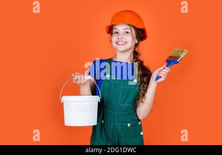 Fröhliche Kinderarbeiter mit Gebäude Uniform und Malerei Eimer und Pinsel, kreative Arbeit. Stockfoto