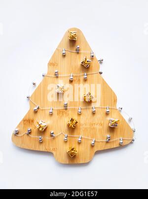 Schöner Weihnachtsbaum aus Holz mit Girlande und Ornamenten auf weißem Hintergrund. Stockfoto