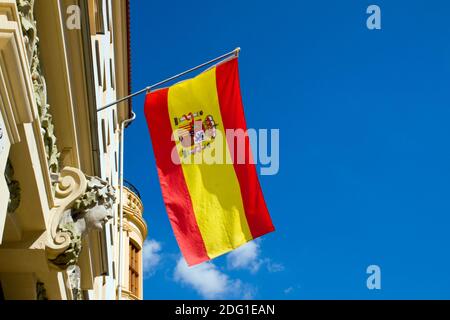 Spanische Flagge winkt an einem alten Gebäude Stockfoto