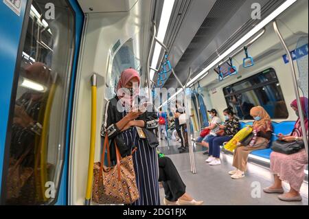 Kuala Lumpur, Malaysia. Dezember 2020. Menschen mit Gesichtsmasken nehmen einen U-Bahn-Zug in Kuala Lumpur, Malaysia, 7. Dezember 2020. Malaysia berichtet 1,600 neue COVID-19 Infektionen, sagte das Gesundheitsministerium am Montag, womit die nationale Summe auf 74,294. Quelle: Chong Voon Chung/Xinhua/Alamy Live News Stockfoto