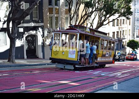 Eine Cable Car-Linie der Powell & Mason Linie fährt den Hügel hinauf auf der Powell Street in der Innenstadt von San Fransisco, Kalifornien, USA. Die Seilbahn ist voll mit Touristen. Stockfoto