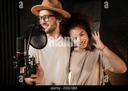 Portrait junger attraktiver Musiker, die Lieder für neue Musik aufnehmen Album im Tonstudio Stockfoto