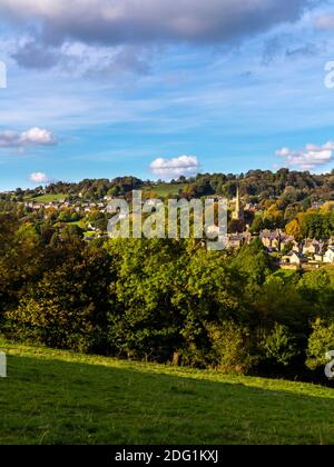 Blick auf Ashover ein Dorf im Nordosten von Derbyshire England in der Nähe des Peak District mit der Kirche und Häuser sichtbar und Bäume im Vordergrund. Stockfoto
