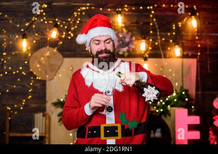 Sei glücklich. weihnachtsmann Champagner-Flasche. Winterfeier. Winterferien. Warten Sie auf Weihnachtsgeschenke. frohe weihnachten. Mann weihnachtsmann Hut. Neujahr Geschenke. weihnachtsdekoration. Glücklich bärtigen Mann Elf. Stockfoto