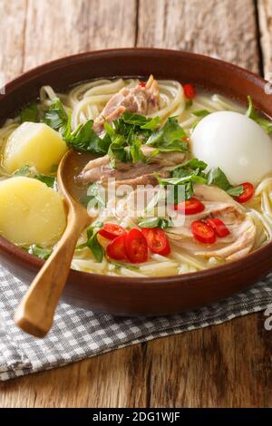 Peruanischen Caldo de gallina Hühnernudel Suppe close-up in einem Teller auf dem Tisch. Vertikal Stockfoto