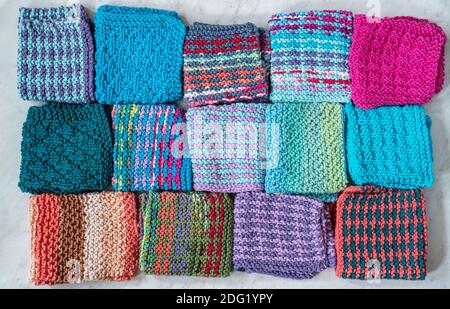 Eine bunte Auswahl an hausgemachten gestrickten Baumwollteller Kleidung. Stockfoto