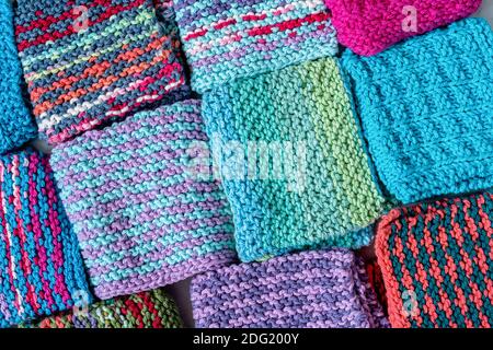 Eine bunte Auswahl an hausgemachten gestrickten Baumwollteller Kleidung. Stockfoto