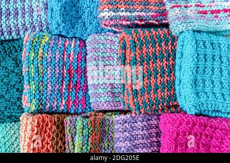 Eine bunte Auswahl an hausgemachten gestrickten Baumwollteller Kleidung. Stockfoto
