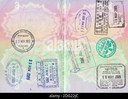 Britische Passseiten mit 2005 Hong Kong ein- und Ausfahrten; 2005 Singapur ein- und Ausfahrten; 2005 Macau ein- und Ausfahrten; und 2012 Gambia (Banjul) ein- und Ausreisestempel Stockfoto