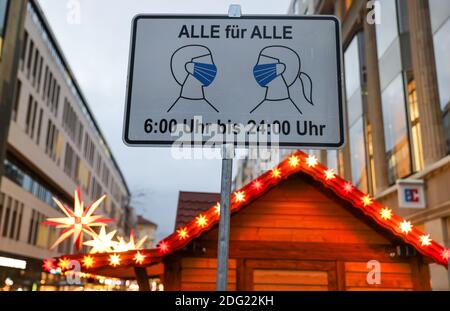 Leipzig, Deutschland. Dezember 2020. Passanten gehen durch die Fußgängerzone in der Grimmaische Straße in der Leipziger Innenstadt hinter einem Schild "Alle für alle" von "6:00 bis 24:00", das darauf hinweist, dass Masken obligatorisch sind. In keinem anderen Bundesland breitet sich die Corona-Pandemie derzeit so schnell aus wie in Sachsen. Daher sind jetzt strengere Maßnahmen in Kraft, einschließlich Ausstiegsbeschränkungen. Alle Weihnachtsmärkte und die traditionellen Bergparaden im Erzgebirge sind abgesagt. Quelle: Jan Woitas/dpa-Zentralbild/ZB/dpa/Alamy Live News Stockfoto