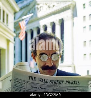 New York 1985, Mann mit US-Dollar-Münzen Gläser beim Lesen des Wall Street Journal, NYSE, Börsenfassade, Manhattan, New York City, NY, NYC, USA, Stockfoto