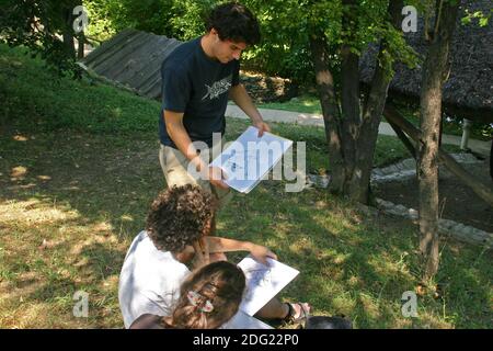 Studenten arbeiten an der Skizze einer Holzmühle im Dorfmuseum in Bukarest, Rumänien Stockfoto