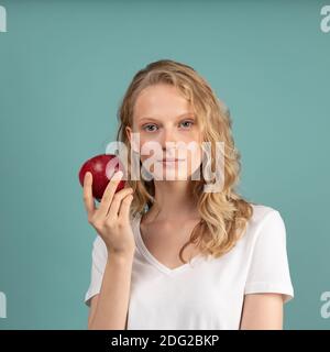 Schöne junge seriöse clevere blonde Frau ohne Make-up mit rot apfel Stockfoto