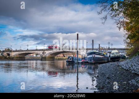 Großbritannien, London, Richmond-upon-Thames / Hounslow, Kew Bridge, eine denkmalgeschützte Brücke über die Themse, Themse bei Ebbe, festgeklammerte Hausboote Stockfoto