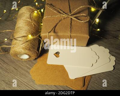 Minimalist Wrapped Paket in braunem Papier mit Tags und String Stockfoto