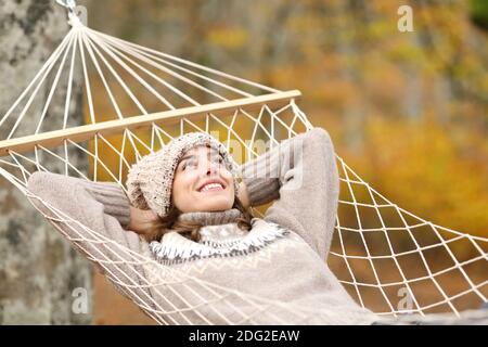 Glückliche Frau im Herbst entspannt in der Hängematte liegen im Herbst In einem Wald Stockfoto