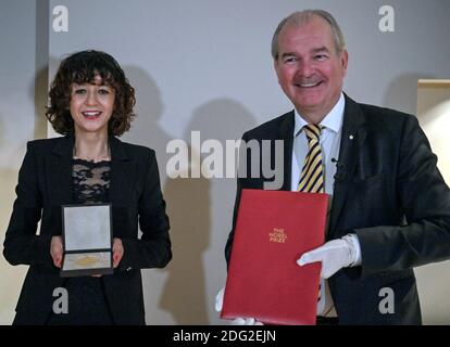 Berlin, Deutschland. Dezember 2020. Die Mikrobiologin Emmanuelle Charpentier zeigt die Medaille für ihren Nobelpreis für Chemie, den sie vom schwedischen Botschafter per Thöresson (r) erhalten hat. Am Montagabend erhielt sie die Urkunde auch in der Berliner Residenz des Botschafters. Denn die traditionelle Preisverleihung am 10. Dezember in Stockholm wird in diesem Jahr aufgrund der Corona-Pandemie nur online stattfinden. Quelle: John MacDougall/AFP/POOL/dpa/Alamy Live News Stockfoto