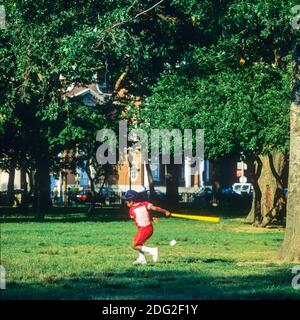 New York 1985, kleiner afroamerikanischer Junge, der Baseball spielt, schwingender Baseballschläger, Battery Park, Lower Manhattan, New York City, NY, NYC, USA, Stockfoto