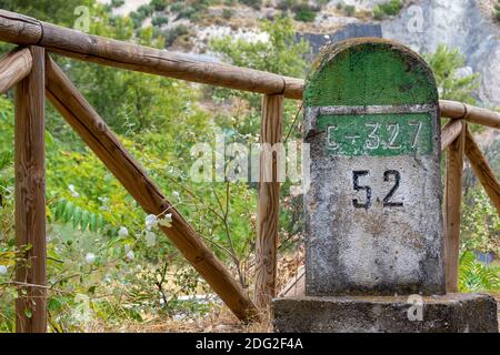 Alte Meilensteine, die auf der Straße Bailen-Motril (N-323) bei der Durchfahrt durch La Cerradura de Pegalajar (Jaen-Spanien) aufgedeckt wurden Stockfoto