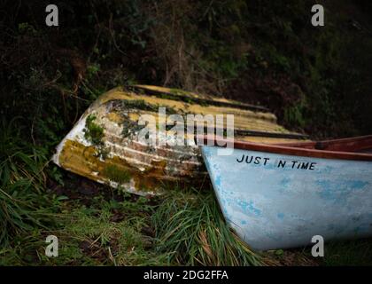 Zwei Boote, die im November 2020 bei Bucks Mills in Devon, Südwestengland, an Land saßen. Einer, der just in time genannt wird, mit einem verlassenen daneben. Stockfoto