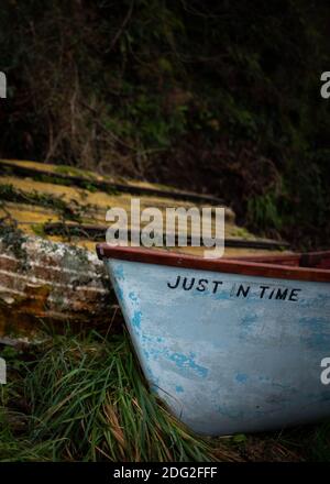 Zwei Boote, die im November 2020 bei Bucks Mills in Devon, Südwestengland, an Land saßen. Einer, der just in time genannt wird, mit einem verlassenen daneben. Stockfoto