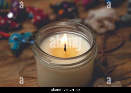 Hausgemachte Kerze in einem Glas Kerzenständer auf einem Holztisch. Komfort zu Hause, Aromatherapie und Entspannung Stockfoto