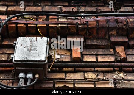 Elektrische Box auf verlassenen Ziegelwand Stockfoto