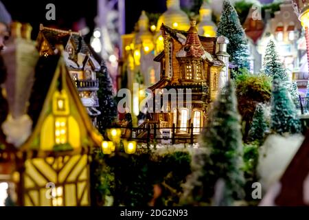 Spielzeughaus European Chocolate Shop am heiligabend in Weihnachtsbäumen in Spielzeugstadt mit glühenden Fenstern. Winter Heiligabend Szene mit traditionellen Stockfoto