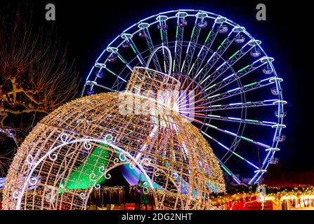 Riesige Weihnachtskugel und Riesenrad. Weihnachtsmarkt in Maastricht, Niederlande. Neujahrsdekoration auf dem Weihnachtsmarkt. Das Riesenrad leuchtet Stockfoto