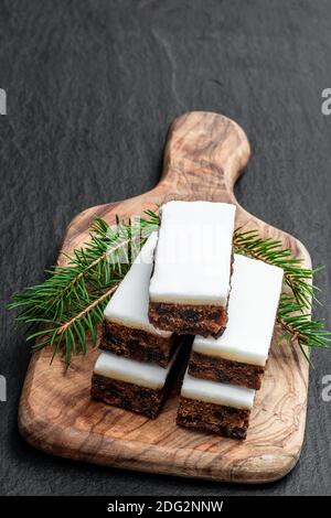 Obstkuchen Scheiben gekrönt mit Marzipan auf schwarzem Stein Hintergrund Stockfoto