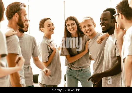 Eine Gruppe von glücklichen jungen Menschen, die in einem hellen Raum stehen Stockfoto