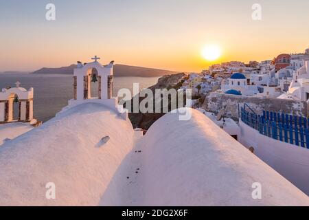 Blick auf traditionelle blaue Kuppelkirchen und weiße Häuser bei Sonnenuntergang in Oia, Santorini, griechische Inseln, Griechenland, Europa Stockfoto