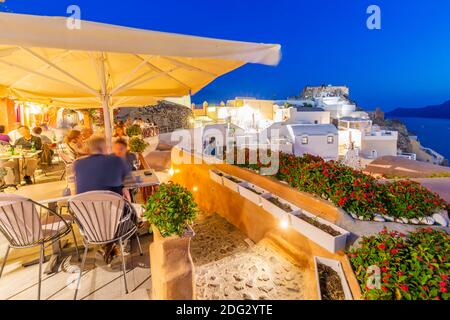 Blick auf die Burg und das Al Fresco Restaurant in der Abenddämmerung in Oia Dorf, Santorini, Ägäische Insel, Kykladen Insel, griechische Inseln, Griechenland, Europa Stockfoto