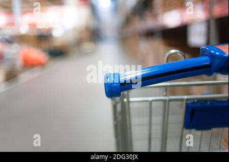 Nahaufnahme des Warenkorbs mit der perspektivischen Ansicht von Shopping Mall Regale mit Waren Stockfoto