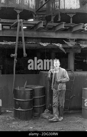 Großbritannien, London, Docklands, Isle of Dogs. Anfang 1974. Ein Mann, der in einem Fabrikhof in der Nähe von Coldharbour arbeitet. Stockfoto