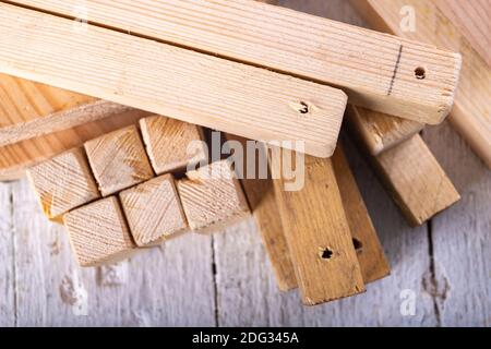 Kleine Holzstücke stapelten sich. Material für die Montage vorbereitet. Heller Hintergrund. Stockfoto