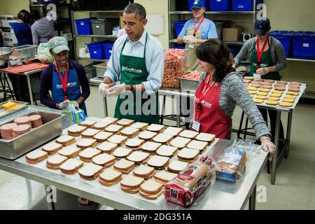 US-Präsident Barack Obama besucht Säcke Sandwiches mit furloughed Bundesarbeiter, einschließlich Dolly Garcia, vorne rechts, die im US Census Bureau arbeitet, und Chantelle Burton, links, die in der Gesundheits-und Human Services-Abteilung arbeitet, Und andere Freiwillige in einer Martha's Table Küche am 14. Oktober 2013 in Washington, DC, USA. In einer Presseerklärung forderte der Präsident den Kongress auf, den Haushaltsstaus zu beenden und den Mitarbeitern des Bundes die Rückkehr zur Arbeit zu ermöglichen. Foto von T.J. Kirkpatrick/Pool/ABACAPRESS.COM Stockfoto