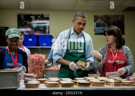 US-Präsident Barack Obama hilft, Sandwiches mit furloughed Bundesarbeitern zu packen, einschließlich Dolly Garcia, rechts, die im US Census Bureau arbeitet, und Chantelle Burton, links, die in der Gesundheits- und Sozialabteilung arbeitet, Freiwilligenarbeit in einer Martha's Table Küche am 14. Oktober 2013 in Washington, DC, USA. In einer Presseerklärung forderte der Präsident den Kongress auf, den Haushaltsstaus zu beenden und den Mitarbeitern des Bundes die Rückkehr zur Arbeit zu ermöglichen. Foto von T.J. Kirkpatrick/Pool/ABACAPRESS.COM Stockfoto