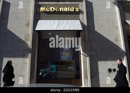 Eine Nonne geht am 4. Januar 2017 in Rom, Italien, an einem neu eröffneten McDonald's-Restaurant in der Nähe des Vatikans vorbei. Die amerikanische Fast-Food-Kette eröffnete ein Restaurant in einem Gebäude im Besitz des Vatikans, trotz des Protests eines Komitees zum Schutz von Borgo, dem historischen Viertel rund um den Vatikan, in dem viele Kardinäle leben. Trotz einer sehr öffentlichen Schlacht von Einheimischen und religiösen Beamten, um die Fast-Food-Kette aus dem päpstlichen Hauptsitz zu halten, öffnete eine Filiale der Golden Arches Kette Restaurant für Geschäfte nur wenige Meter vom Petersplatz entfernt. Einige Kardinäle beschwerten sich darüber, dass sie nicht konsultiert wurden Stockfoto