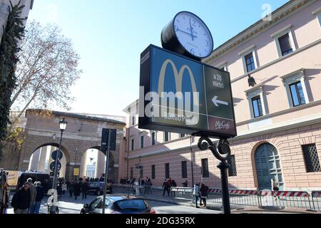 Ein Schild, das die Richtung eines neu eröffneten McDonald's-Restaurants zeigt, ist am 4. Januar 2017 in Rom, Italien, in der Nähe des Vatikans zu sehen. Die amerikanische Fast-Food-Kette eröffnete ein Restaurant in einem Gebäude im Besitz des Vatikans, trotz des Protests eines Komitees zum Schutz von Borgo, dem historischen Viertel rund um den Vatikan, in dem viele Kardinäle leben. Trotz einer sehr öffentlichen Schlacht von Einheimischen und religiösen Beamten, um die Fast-Food-Kette aus dem päpstlichen Hauptsitz zu halten, öffnete eine Filiale der Golden Arches Kette Restaurant für Geschäfte nur wenige Meter vom Petersplatz entfernt. Einige Kardinäle beschwerten sich darüber Stockfoto