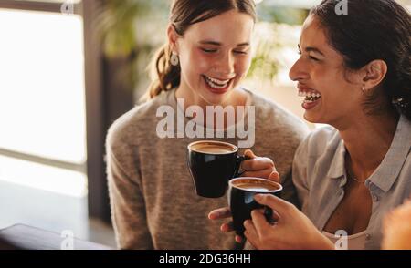 Zwei Freunde, die zusammen in einem Café Kaffee trinken. Beste Freunde gossing über Kaffee in einem Café. Stockfoto