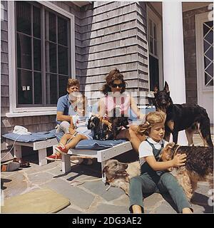 US-Präsident John F. Kennedy, John F. Kennedy Jr., First Lady Jacqueline Kennedy, Caroline Kennedy. Hunde: Clipper (stehend), Charlie (mit Caroline), Wolf (liegend), Shannon (mit John Jr.), zwei von Pushinkas Welpen (mit Mrs. Kennedy). Hyannisport, MA, USA, am 14. August 1963. Foto von White House / CNP Stockfoto
