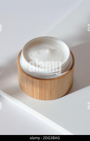 Feuchtigkeitsspendende Creme im umweltfreundlichen Bambusglas. Natürliche organische kosmetische Verpackung Design. Handhautpflege-Konzept. Stockfoto