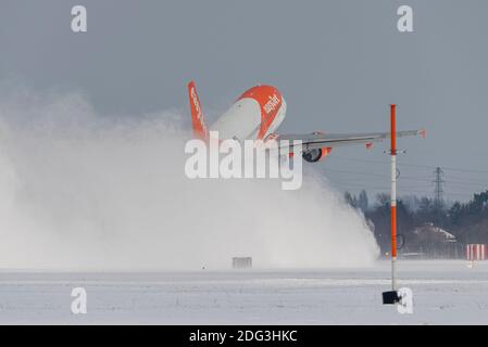 EasyJet Airbus A319-Düsenflugzeug, das eine Schneewolke weht, als es vom London Southend Airport nach Alicante abfliegt. Bestie aus dem Ostwetter Stockfoto
