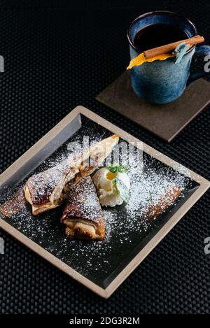 Verschiedene Desserts mit Tee auf schwarzem Hintergrund Stockfoto